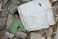 The NASA astronaut Nicole Stott moving a storage container inside HTV-1.
