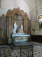 Retable en bois polychrome. Deux statues, dont une du Christ, encadrent un Sacré Cœur. En bas, un aigle doré (référence à Bossuet)