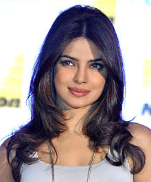 Priyanka Chopra posing at a film festival in dark sari looking towards the camera