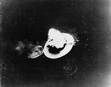 Black and white photo of a large explosion on a body of water