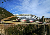 24. KW Der ÖBB-EuroCity 562 auf der Trisannabrücke (Arlbergbahn). Im Hintergrund das Schloss Wiesberg in der Gemeinde Tobadill, Tirol.