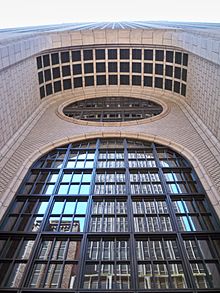 View of the main entrance arch from ground level. There is a tall arched window and an oculus above it. The ceiling of the arch is divided into a grid.