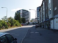 Övre delen av Torsviks backe med bostadshus inrymmande butiker i gatuplanet. Vy mot öster. Foto: Augusti 2009.