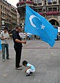 Uyghur man with the Kökbayraq in Munich, Germany