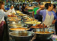 Sebuah gerai pasar di pasar Thanin di Chiang Mai, Thailand menjual makanan yang dimasak