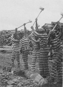 Photo de prisonniers en costume rayé en train de casser des cailloux.