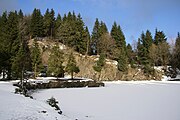 Die Reliefwirkung bei Felsen und Bäumen wird durch Licht- und Schatten-Bildung deutlich, wohingegen die glatte Schneefläche einheitlich weiß bleibt. Bergsee Ebertswiese im Winter.