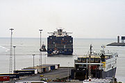 Een containerschip vaart de haven uit.