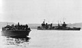 New Orleans seen after the Battle of Tassafaronga near Tulagi on 1 December 1942. The PT boat in the foreground is carrying survivors from Northampton.