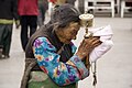 Femme tibétaine âgée portant un moulin à prières dans le circuit de pèlerinage. bouddhiste du Barkhor à Lhassa au Tibet.