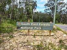 Photograph of an official sign for the national park at one of its road boundaries using the pluralised word, "forests".