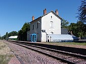 Photographie en couleurs d'un bâtiment le long d'une voie ferrée.