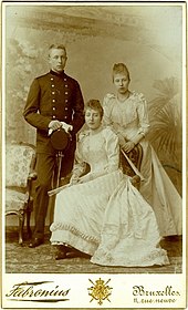 Henriette, en tenue longue et éventail en mains est assise et pose avec son frère Albert debout en uniforme militaire et sa sœur Joséphine également debout en tenue claire tenant aussi un éventail