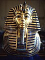 Maschera funeraria di Tutankhamon. Tutankhamon, figlio di Akhenaton, riportò l'Egitto all'antica religione. Morì giovane, ma seppur non fu considerato significante nel proprio tempo, la scoperta della sua tomba KV62, rimasta intatta, nel 1922 da parte Howard Carter lo ha reso rilevante come simbolo dell'Antico Egitto nel mondo moderno.
