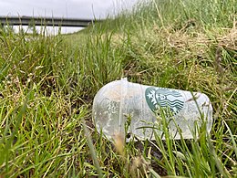 Een weggegooide plastic beker van Starbucks, op 16,1 km van de dichtsbijzijnde Starbucksvestiging, ligt in het gras langs een landweg bij Wilp.