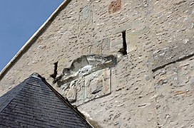 Photographie en couleurs de bas-reliefs représentant des personnages enchâssés dans un mur.