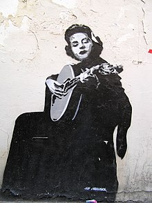 Mural of a seated Amália Rodrigues playing a lute-like instrument