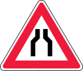 Road narrows on both sides