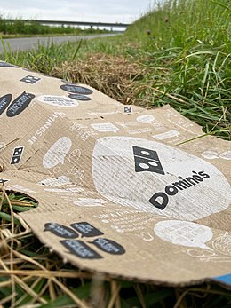 Langs een landweg bij Wilp ligt een pizzadoos van Domino's. Uit onderzoek blijkt dat pizzadozen van deze keten PFAS bevatten.