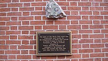 The inscription reads: "This piece of the Berlin Wall stood near Lichterfelde until broken by the sledgehammer of Mr. Rick DeLisle on November 11, 1989, at 6:50 am. Donated by WMIX 106.5 FM Baltimore and dedicated to those who crossed and those who gave their lives in the attempt."