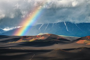 Cone sul do vulcão Plosky Tolbachik formado durante a penúltima erupção vulcânica em 1975–1976. Tolbachik é um vulcão complexo no leste da região de Kamtchatka, na parte sudoeste do grupo de vulcões Kliutchevskaia, Rússia. Consiste em dois vulcões, um vulcão em escudo com um cume achatado (Plosky Tolbachik, ativo, altura 3 140 m) e um estratovulcão extinto com um cume pontiagudo (Ostry Tolbachik, 3 682 m) fundidos com as bases, localizadas no pedestal de um antigo vulcão em escudo. Em 27 de novembro de 2012, uma erupção estromboliana ocorreu a partir de duas fissuras. Os fluxos de lava basáltica moveram-se com velocidade relativamente alta e destruíram alguns edifícios a uma distância de 4 km. A erupção durou mais de um mês e a lava continuou a sair das fissuras durante este período. (definição 8 070 × 5 385)