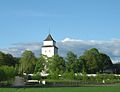 Haug kirke ligger på en høyde over Drammenselva og Hokksund, med Eiker prestegård i umiddelbar nærhet. Foto: Cavernia, 2010