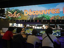 Stand de Dofus et Wakfu à la Japan Expo 2012. Sous un grand panneau Dofus, quatre joueurs testent le jeu Wakfu.