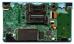 A large and small printed circuit board connected together. A metal chassis and main electronic components dominate opposite ends of the large PCB.