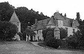 Photographie en noir et blanc d'un château du hameau qui l'entoure.