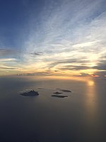 Pohled z východu na souostroví Krakatoi, obklopené vodami Sundského průlivu. Rakata (vlevo), Verlaten (vpravo nahoře), Anak Krakatau (vpravo uprostřed) a Lang (vpravo dole).