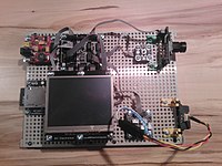 Doma sestavená fotografická past z .NET Gadgeteer ovládaná infračerveným dálkoměrem. Pořizuje fotografie pomocí jednoduchého modulu webové kamery v rozlišení 320 x 240 bodů s ručním ostřením.