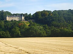 Photographie d'un château au fond de champs ouverts.