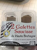 Emballage plastique contenant deux saucisses enroulées dans deux galettes.