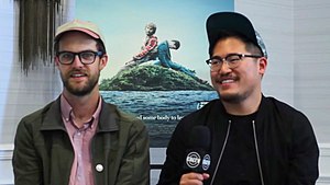 Daniels smiling in front of a film poster