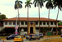 Former YMCA building in Panama Canal Zone, a gold and white building, now fenced off from the public.