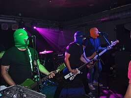 Masked Intruder performing in September 2014; from left to right: Intruder Green, Intruder Red (off-camera) Intruder Blue and Intruder Yellow