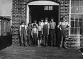 A group of doffers working in Cotton Factory posed by the superintendent of the factory. November 1910. Photographed by Lewis Hine.