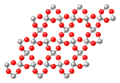 Silice cristallisée (SiO2)n (atomes Si en gris et O en rouge)