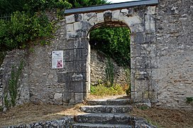 Photographie en couleurs d'une porte percée dans une cortine.