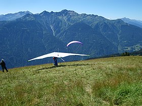 Deltaplane au décollage au Signal de Bisanne avec le mont Mirantin de l'autre côté de la vallée du Doron de Beaufort en direction du sud.