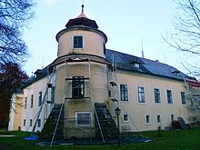 Mittig der südliche, runde Eckturm des Schlosses mit drei Geschoßen, daran sich zu beiden Seiten anschließend zweigeschoßige Schlossflügel