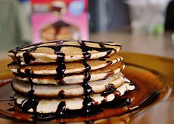 Stacked American pancakes with chocolate sauce