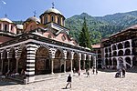 Church with frescos, courtyard with tourists in front