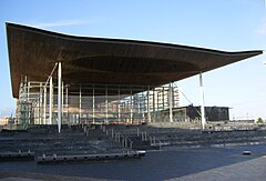 A building with a flat wooden roof and a glass façade around the entire building