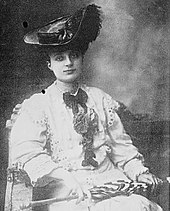 Photographie d'Anna de Noailles assise avec un chapeau sur la tête.