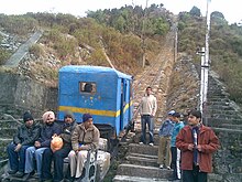 Single-car train on an incline, surrounded by people