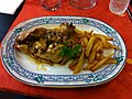 Poulet en pepitoria, accompagné de croûtons de pain frits et de frites.