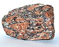 Granit o fluidalnej teksturze z płynięcia z piroalmandynem. Widoczne także zbliźniaczenia skalenia potasowego.