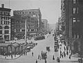 First Avenue looking north from James Street in 1916 with the Pioneer Square pergola and totem pole bordered by the Pioneer Building (far right) and Mutual Life Building (far left).