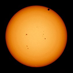 Transit de Vénus de juin 2012 (photographie prise le 5 juin 2012 à San Francisco). La face sombre de la planète est visible en haut à droite du disque solaire, dont on aperçoit quelques taches au centre. (définition réelle 2 577 × 2 577)